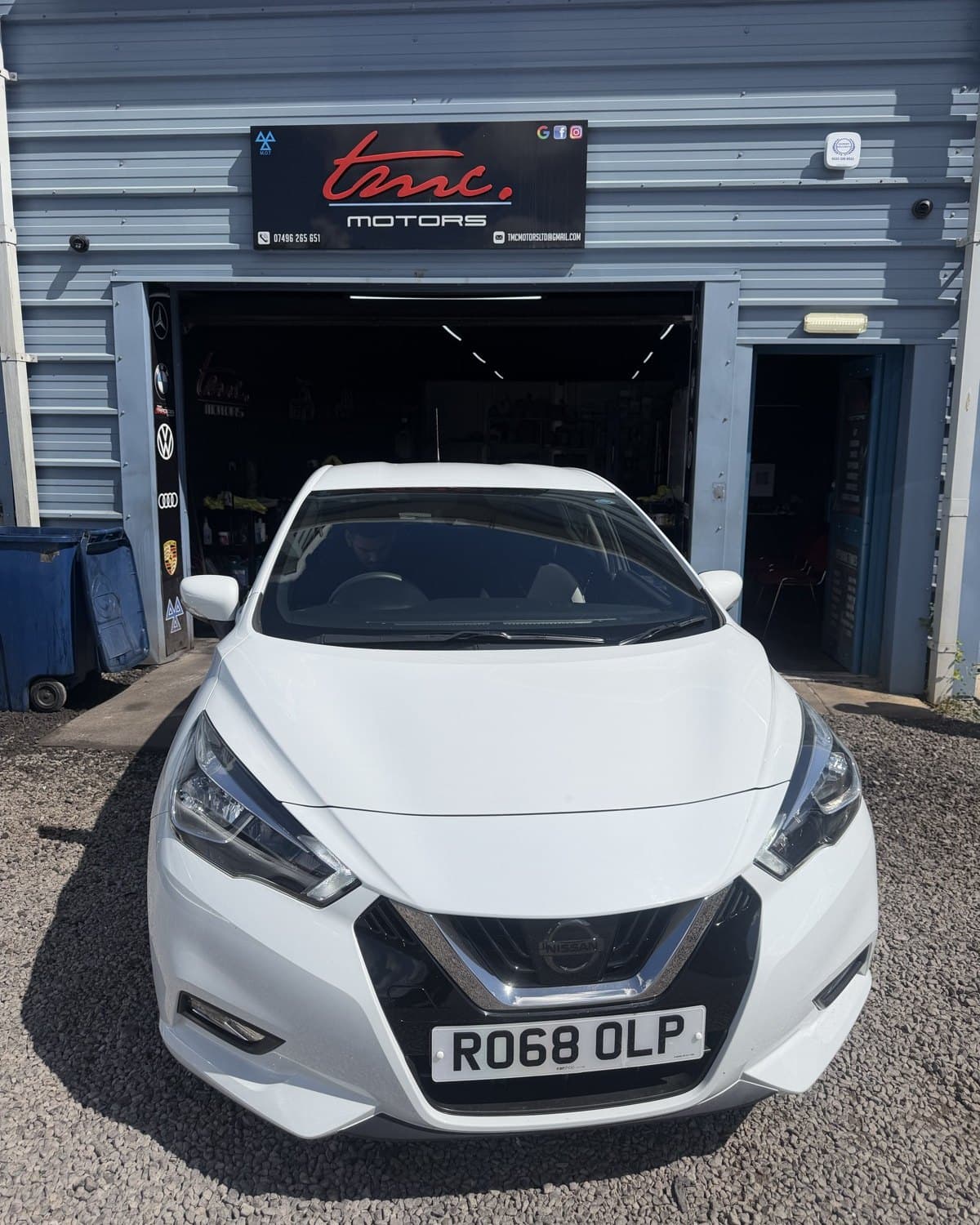 A white Nissan Micra outside the Team Mercedes Cardiff workshop shutter