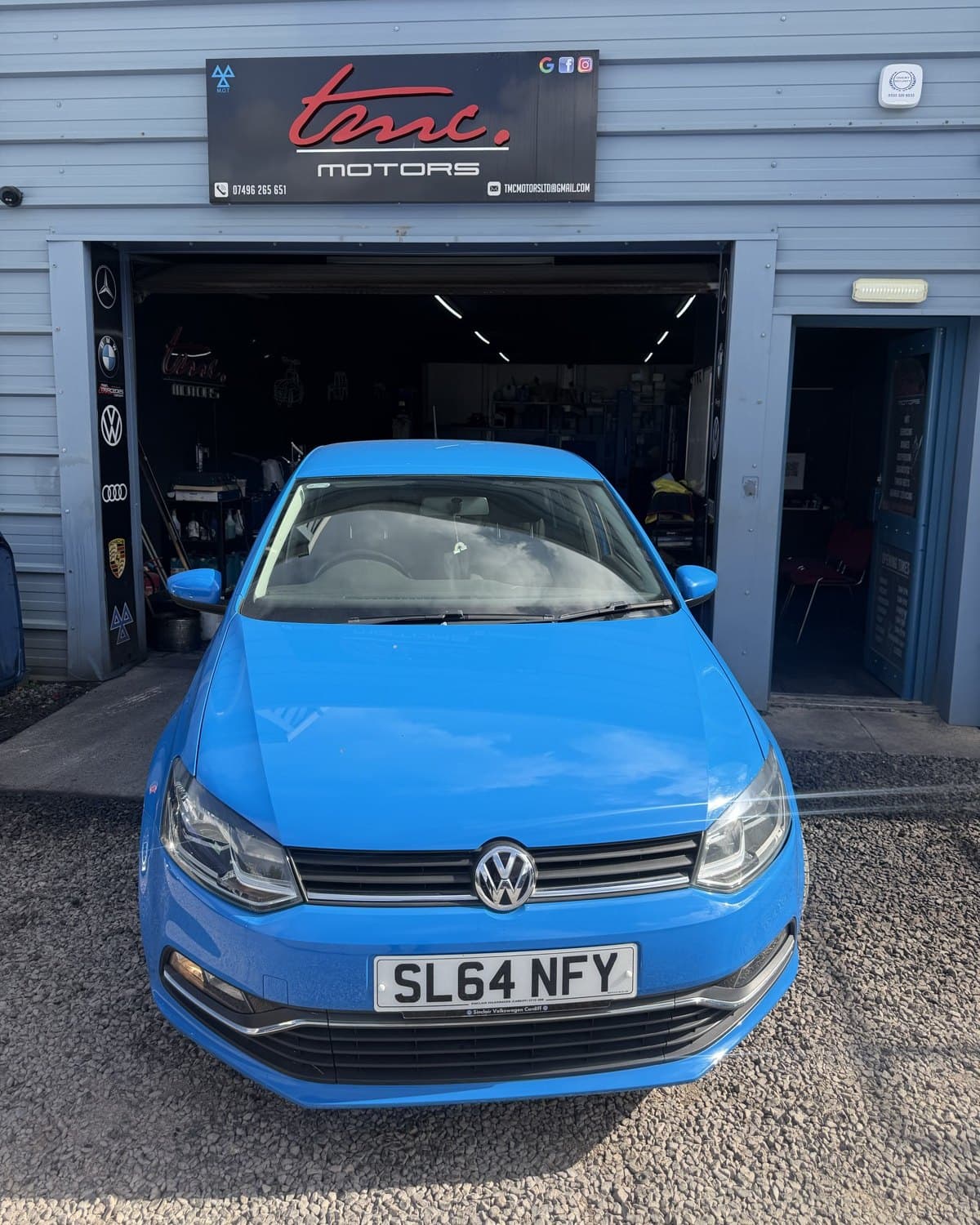 A blue Volkswagen Polo outside the Team Mercedes Cardiff workshop shutter