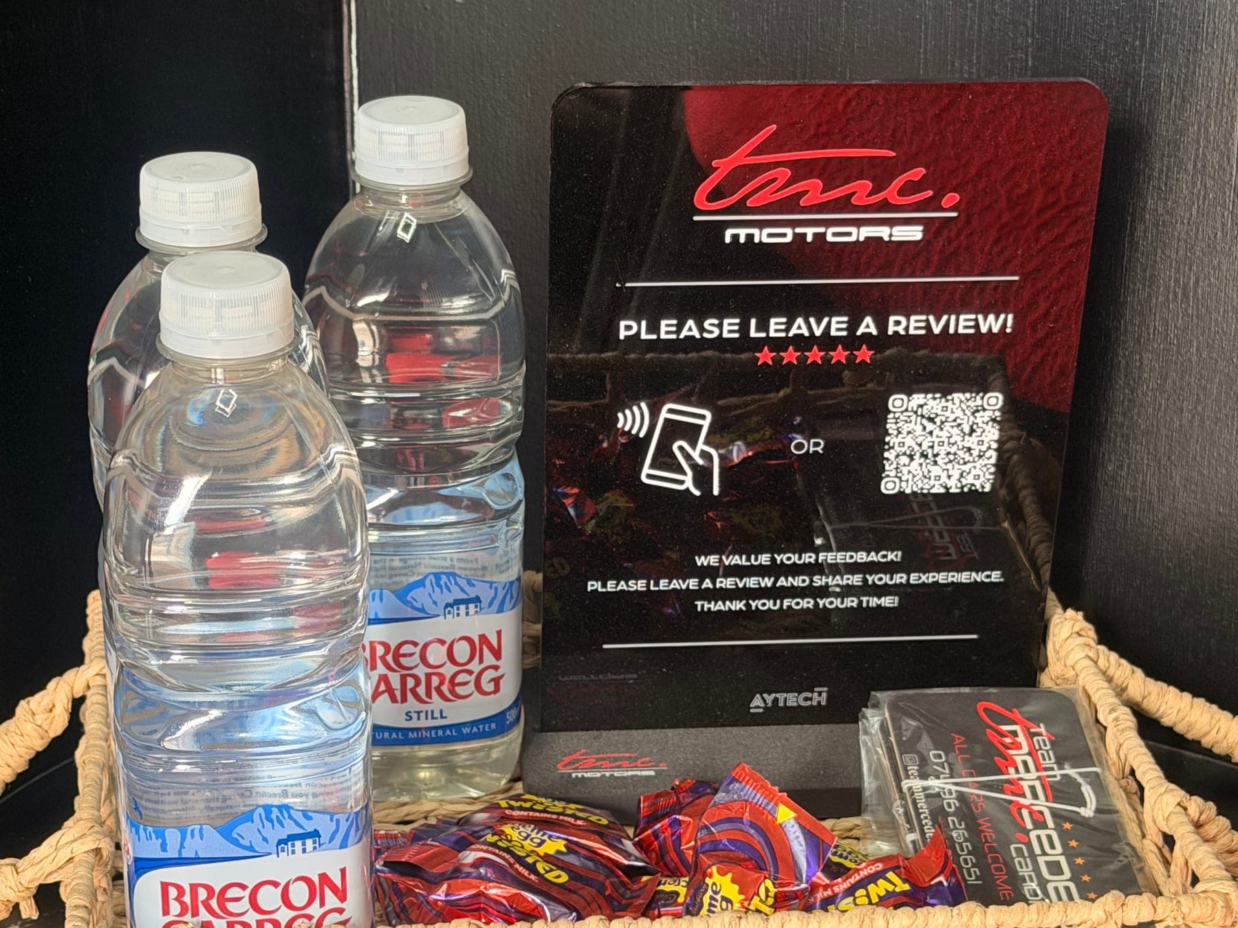 Bottled water, sweets and a Team Mercedes Cardiff review card on the counter in the workshop reception