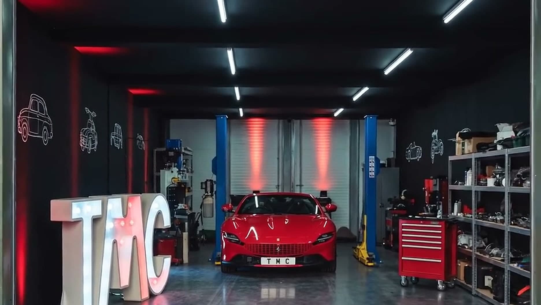 The Team Mercedes Cardiff workshop, with two-post lifts, parts shelving and the roller shutter open