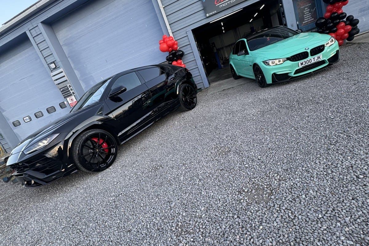 A BMW M4 and other cars outside the Team Mercedes Cardiff workshop
